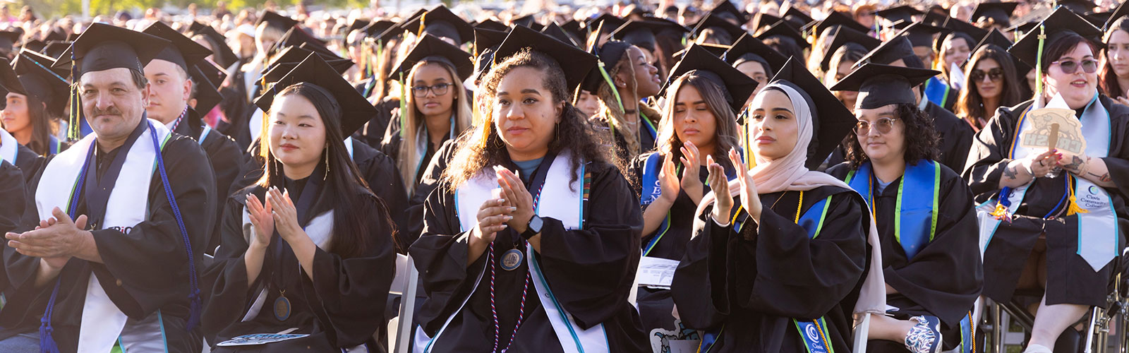 Rows of graduating students sitting and listening.