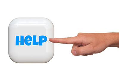 A finger points at a blue help button