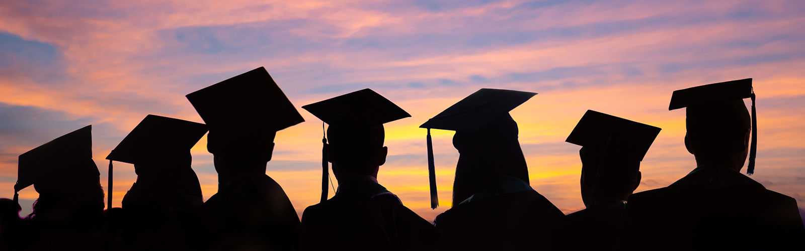silhouette of graduates against a sunset